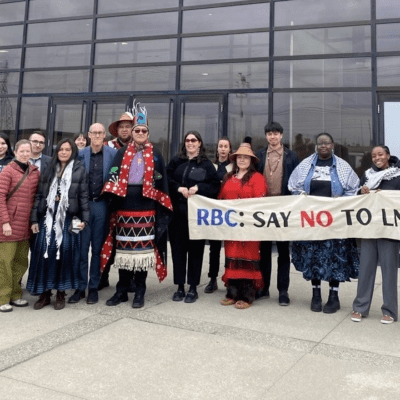 group of Indigenous leaders & climate advocates outside the RBC 2025 shareholder meeting with a banner reading "RBC: Say no to LNG"
